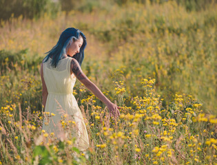 Wall Mural - Beautiful girl walking on flower field