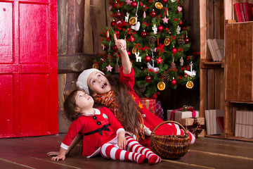 Wall Mural - Two little girls decorating Christmas tree. New year preparation. Happy family