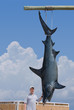 © Michael O'Keene - Fisherman posing with his catch of a giant mako shark that is hanging from a pole.