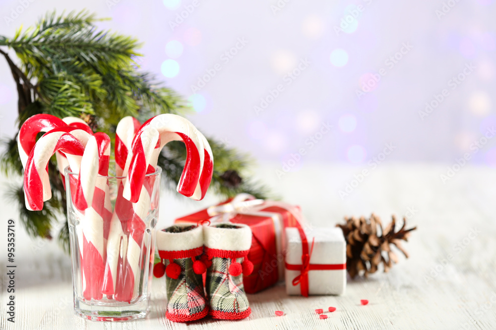 Christmas Candy Canes in glass on table on light background