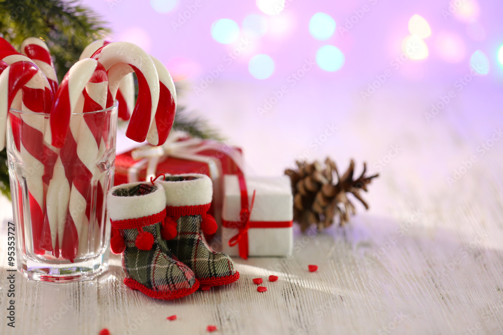 Christmas Candy Canes in glass on table on light background