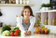 © lenets_tan - Young woman sitting near desk in the kitchen