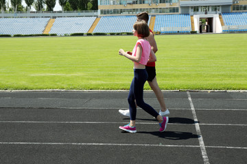 Wall Mural - Young people jogging on stadium