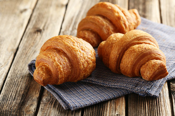 Wall Mural - Tasty croissants on brown wooden background