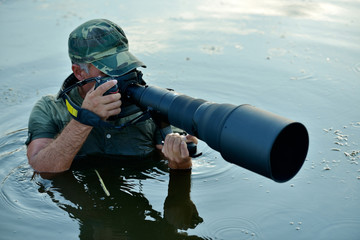 Wall Mural - wildlife photographer outdoor, standing in the water