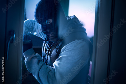 Cuadros en Lienzo burglar with crowbar breaking into a house