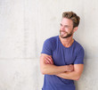 © mimagephotos - Smiling confident guy with beard posing with arms crossed