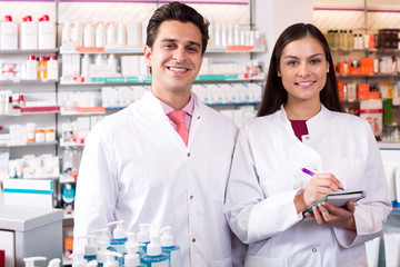 Wall Mural - Portrait of two friendly pharmacists working