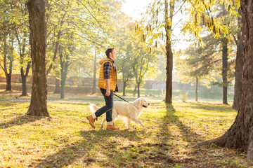 Young man walking his dog in a park