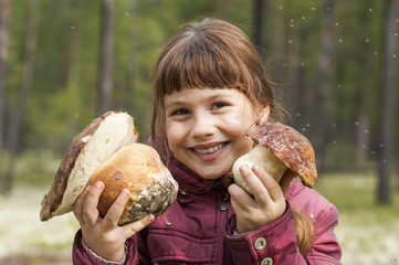 Joyful girl holding two large white mushroom.