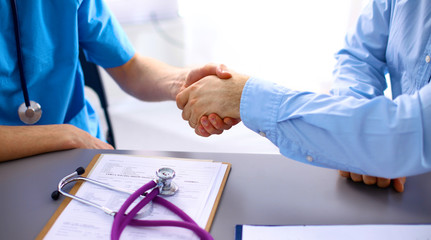 Female doctor holding application form while consulting patient