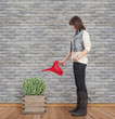 © asierromero - beautiful young woman watering a plant