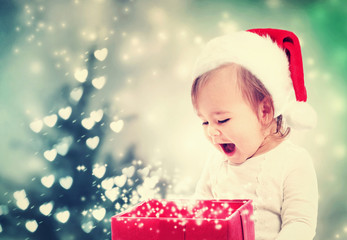 Wall Mural - Happy Toddler girl looking at Christmas present box