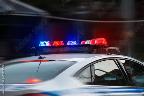 Cuadros en Lienzo Un coche de policía se apresura a la llamada de emergencia con las luces encendi
