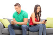 © Ljupco Smokovski - Young couple ignoring each other seated on a sofa