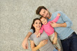 © goodluz - Upper view of family of three laying on carpet