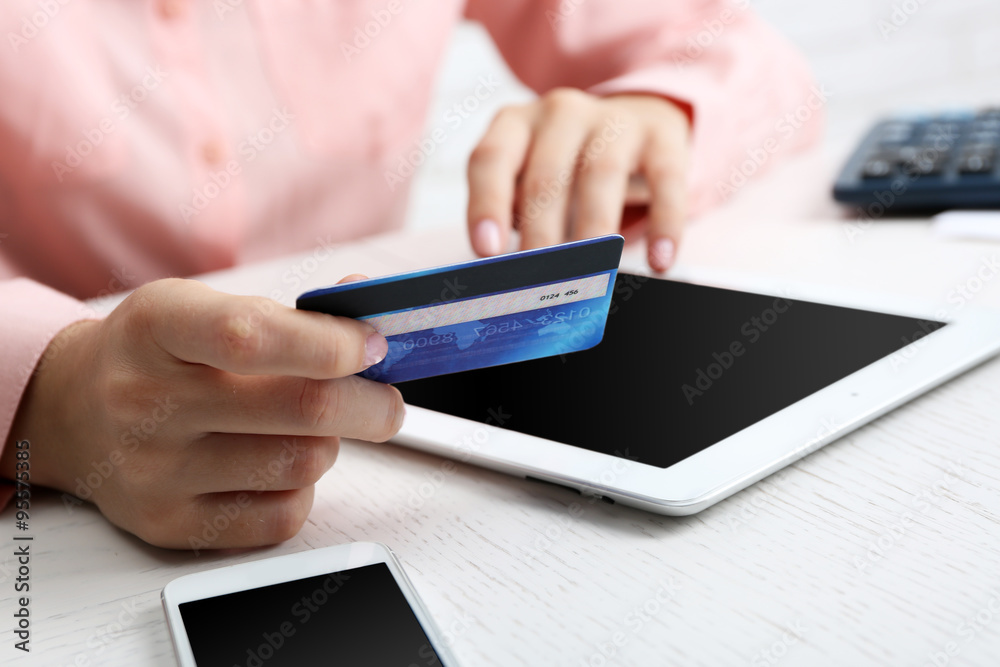 Concept for Internet shopping: hands with digital tablet and credit card
