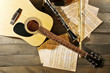 Acoustic guitar, soprano saxophone, violin, flute and note sheets on wooden background