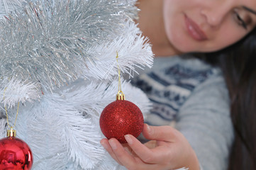 cropped shot of young woman decorating her Christmas tree at hom