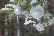 Winter Pine Tree Branches With Glitter Reindeer Ornament And Christmas Baubles At Wood Background