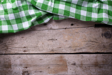 Wall Mural - Green checkered kitchen towel  on vintage  wooden background.