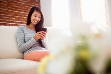Asian Woman Reading Text On Couch