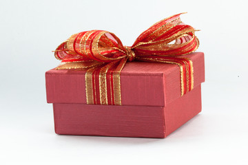 Red gift box with a red ribbon and bow in white isolated backgro