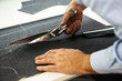 Tailor cutting fabric with large scissors