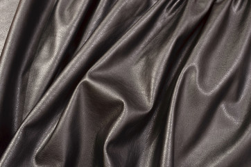 Wall Mural - Close up on crumpled black leather material textured fabric. Shiny black pleather as a background.