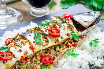 Asian style mackerel with ginger, red chilli, coriander and spring onion on a baking tray, ready to bake