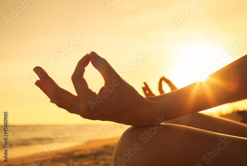 Foto Close-up hand of a woman meditating on the beach.