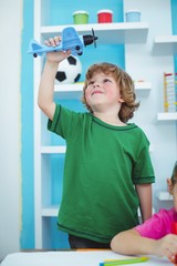 Wall Mural - Small boy playing with a toy plane