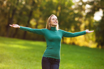 Wall Mural - Happy woman standing in park and enjoying nature