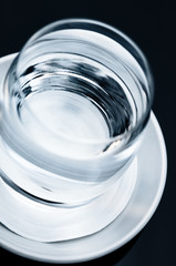 Single glass of clean clear drinking water tilted tilt view close up macro on the table