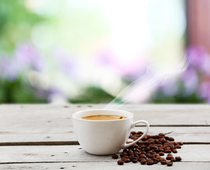 Poster - Cup of coffee on table on bright background