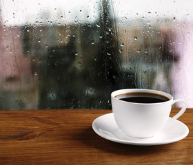 Poster - Cup of coffee on table on window background