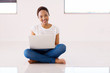 african american woman sitting on floor using laptop