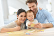 © goodluz - Parents with baby girl playing with wooden game