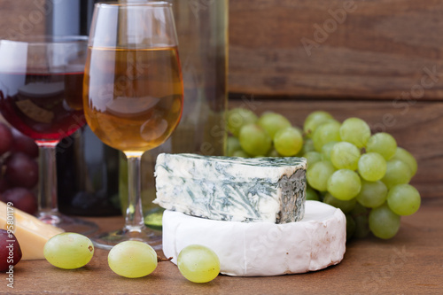 Wine pouring into wine glass. Cheese, grapes in restaurant. Poster