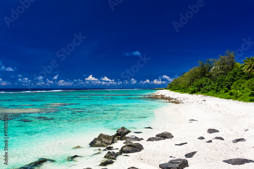 Fotografie, Obraz Beach with white sand and black rocks on Rarotonga, Cook Islands