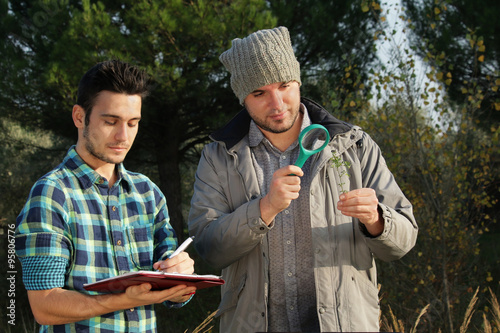Fotografie, Obraz ecologists at work in a nature park doing scientific research on plant species
