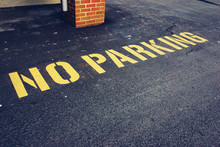 The Words No Parking Painted On Pavement