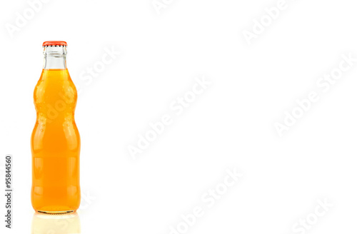 Fotografia Glass bottle of orange soda isolated on white background