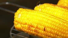 Healthy Vegetarian Barbecue With Ripe Golden Corn On Coals And Turn It Around By Using Barbeque Tongs, Close Up