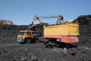 Coal mining. The dredge loads the truck coal.