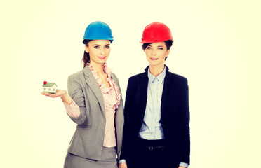 Two architects women with house model.