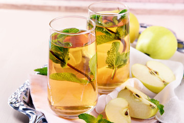 Canvas Print - Glasses of apple juice with fruits and fresh mint on table close up