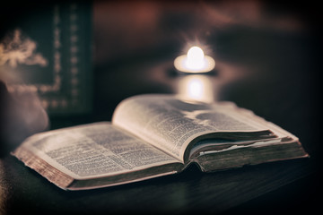 Wall Mural - Bible with candles in the background.