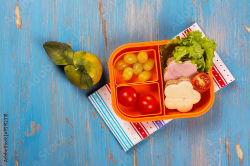 Fototapeta dla dzieci School lunch box for kids. Funny flower shaped sandwiches, fruits, vegetables and juice. Selective focus