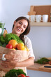 © lenets_tan - Young woman holding grocery shopping bag with vegetables